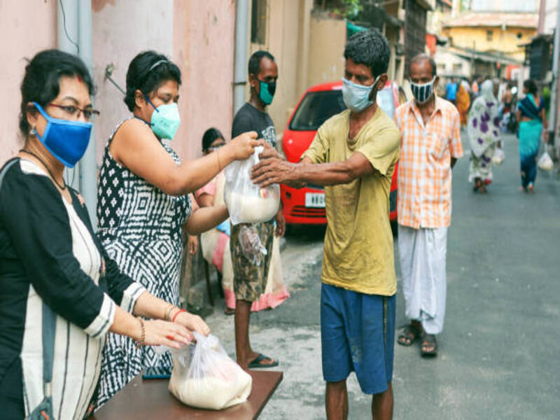 Civic volunteers of a social welfare association helping poor people by giving them grocery items like rice, pulses etc. during lockdown period in Kolkata. People are seen waiting in line. All of them are seen wearing face masks / cloths as a preventive measure.
Shot at Lansdowne, Kolkata on 05/10/2020.